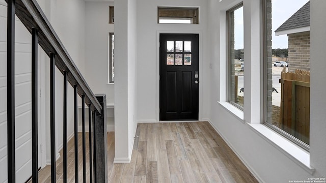 entryway featuring stairway, light wood-style flooring, and baseboards