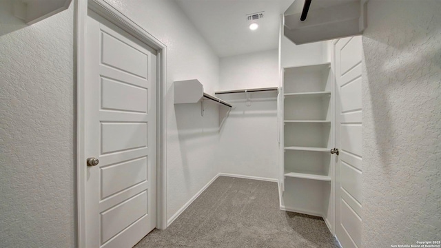 spacious closet with carpet flooring and visible vents