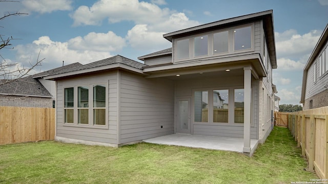 back of house with a patio, a lawn, and a fenced backyard