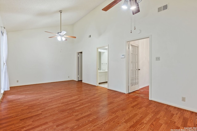 unfurnished living room featuring light hardwood / wood-style floors, high vaulted ceiling, a textured ceiling, and ceiling fan