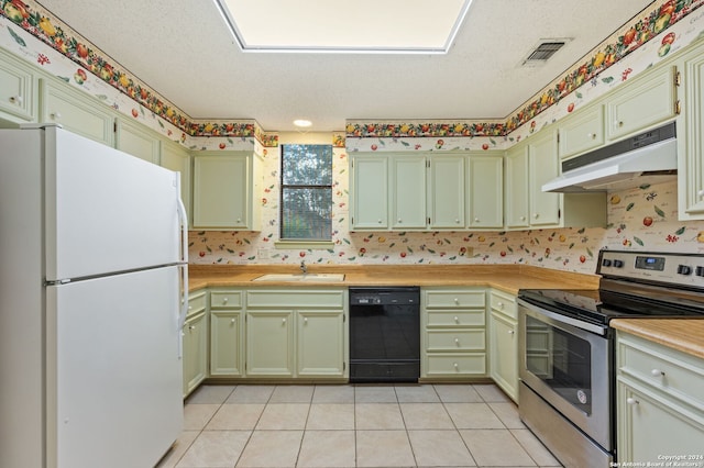 kitchen with stainless steel electric range, light tile patterned floors, a textured ceiling, dishwasher, and white refrigerator