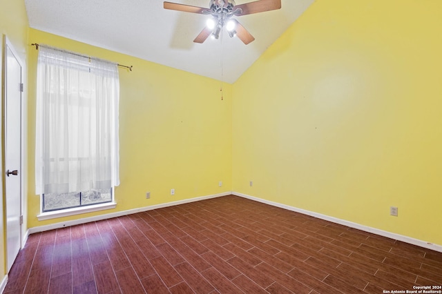 empty room with ceiling fan, lofted ceiling, and dark hardwood / wood-style flooring