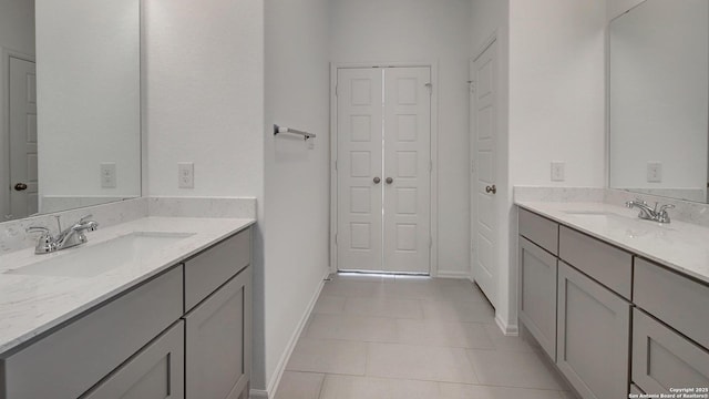 bathroom with a sink, two vanities, and tile patterned flooring