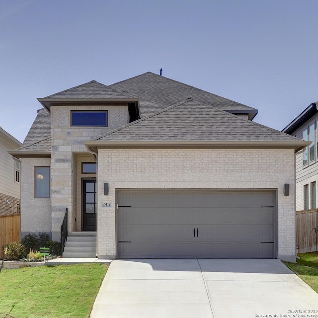 view of front facade featuring brick siding, an attached garage, and a shingled roof