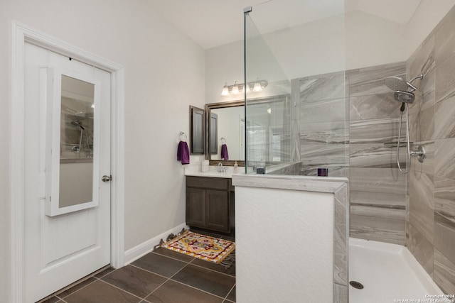 bathroom featuring vanity, a tile shower, and tile patterned floors