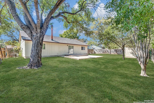 rear view of house featuring a yard and a patio