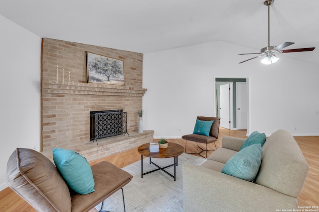 living room featuring a brick fireplace, hardwood / wood-style flooring, ceiling fan, and vaulted ceiling