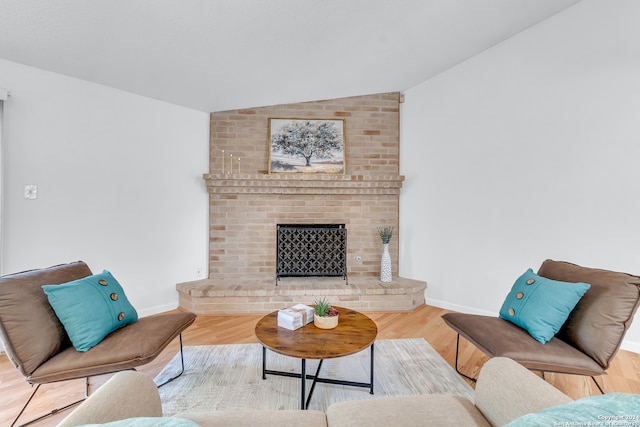 living room featuring hardwood / wood-style flooring, vaulted ceiling, and a fireplace