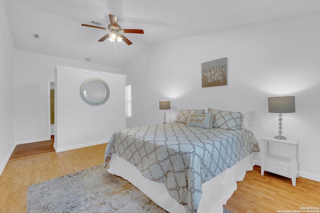 bedroom with lofted ceiling, hardwood / wood-style floors, and ceiling fan