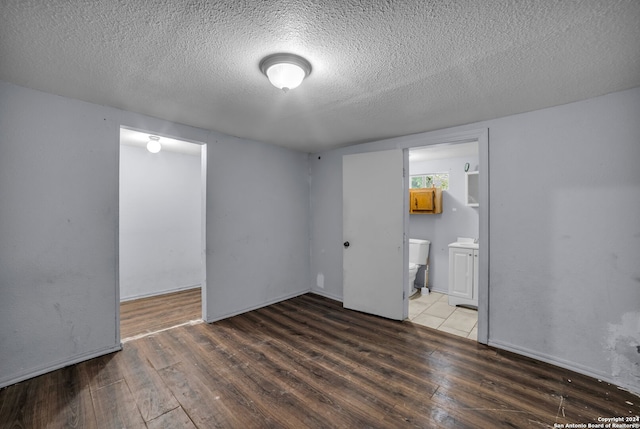 unfurnished room featuring a textured ceiling and dark wood-type flooring