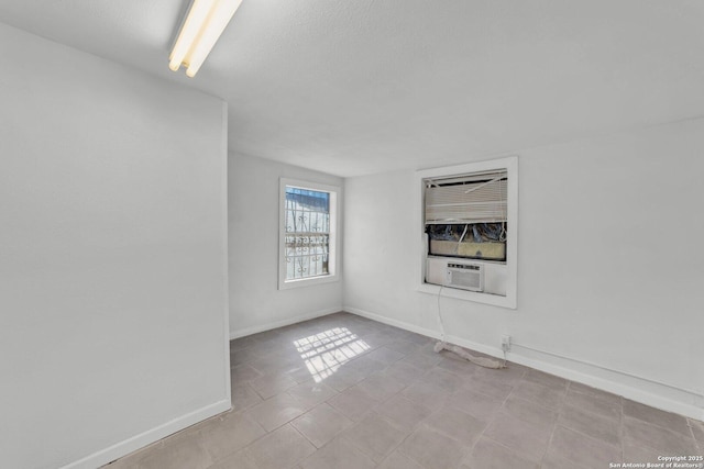 811 General Mcmullen Dr, San Antonio, TX 78237 - empty room with cooling unit, a textured ceiling, tile patterned flooring, and baseboards