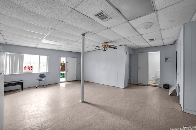 basement with a paneled ceiling and ceiling fan