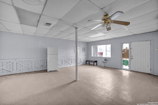 basement featuring ceiling fan, a paneled ceiling, and white refrigerator