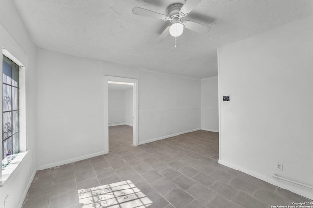 811 General Mcmullen Dr, San Antonio, TX 78237 - unfurnished room with a textured ceiling, a healthy amount of sunlight, a ceiling fan, and baseboards