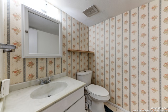 bathroom featuring vanity, toilet, and a textured ceiling