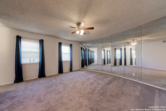 unfurnished bedroom with ceiling fan, a textured ceiling, and carpet floors