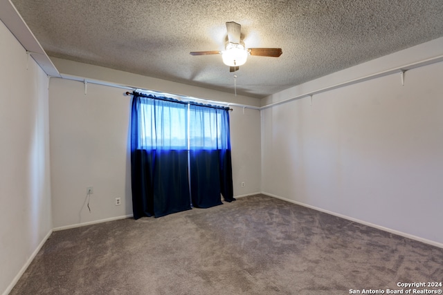 carpeted empty room with ceiling fan and a textured ceiling