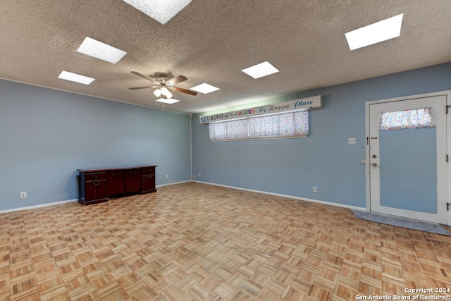 spare room with a textured ceiling, light parquet floors, and ceiling fan