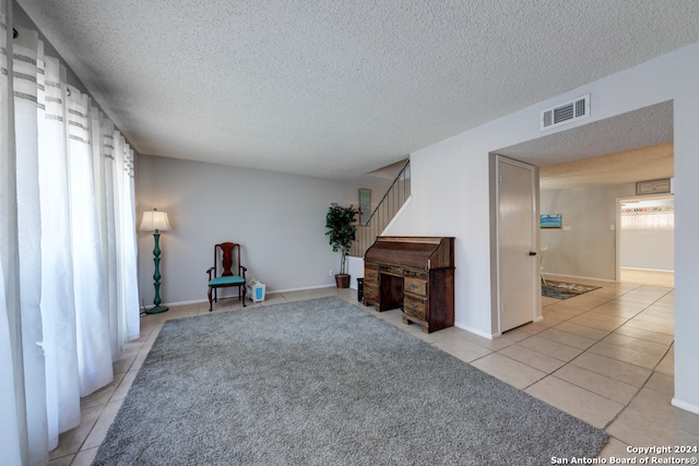 living area featuring light tile patterned flooring and a textured ceiling