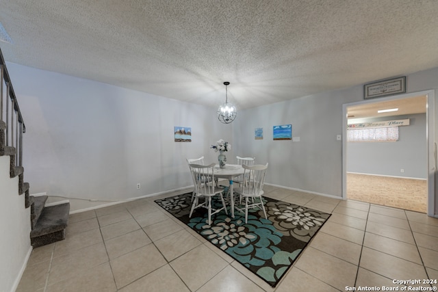 dining space featuring a notable chandelier, a textured ceiling, and light tile patterned floors