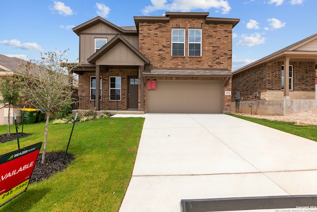 view of front of house with a garage, a porch, and a front yard