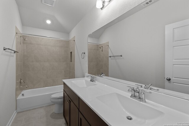 full bathroom featuring tiled shower / bath, vanity, toilet, and tile patterned flooring