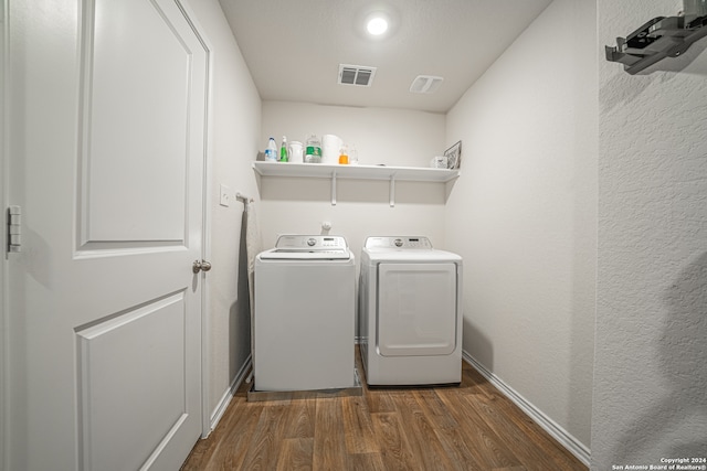 clothes washing area with independent washer and dryer and dark hardwood / wood-style floors