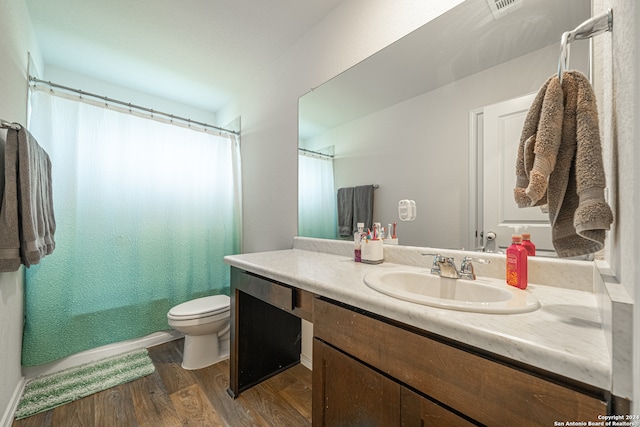 bathroom with vanity, curtained shower, hardwood / wood-style flooring, and toilet