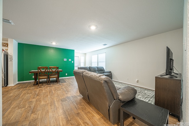 living room featuring light hardwood / wood-style floors and a textured ceiling