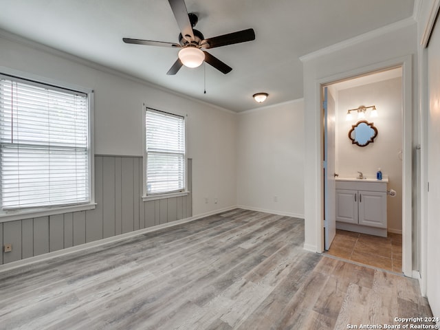 unfurnished room with sink, crown molding, light hardwood / wood-style floors, and ceiling fan