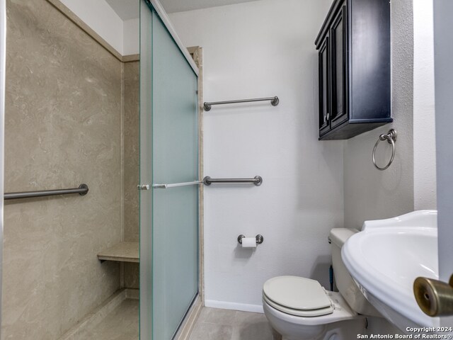 bathroom with sink, tile patterned flooring, toilet, and walk in shower