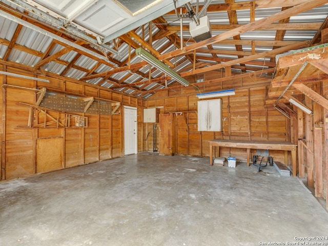 garage with a garage door opener and wood walls