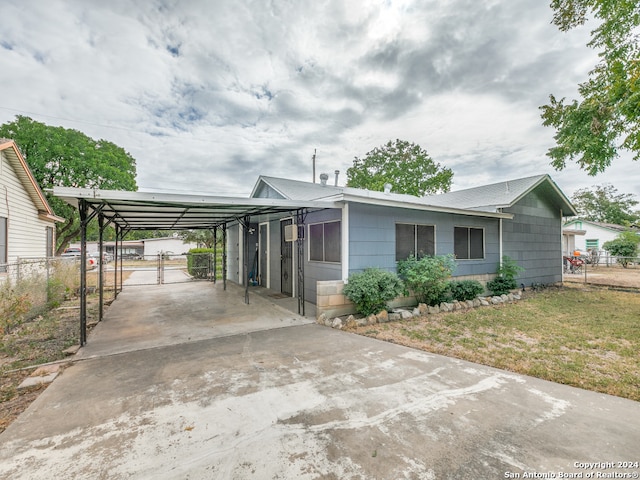 view of front of home with a carport and a front lawn