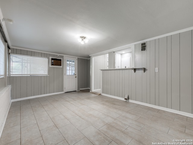 interior space featuring an AC wall unit, ornamental molding, and wooden walls