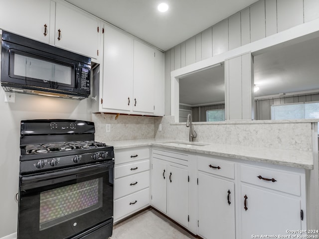 kitchen with white cabinetry, black appliances, sink, and decorative backsplash