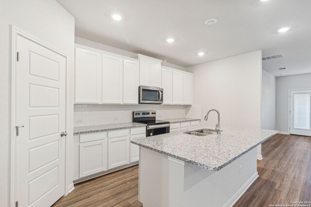 kitchen featuring stainless steel appliances, white cabinetry, a kitchen island with sink, and sink