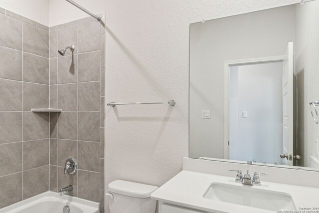 full bathroom with tiled shower / bath combo, toilet, and vanity