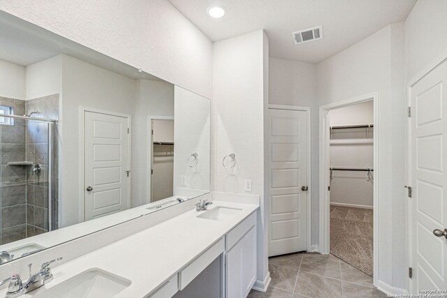 bathroom with tile patterned floors, vanity, and walk in shower