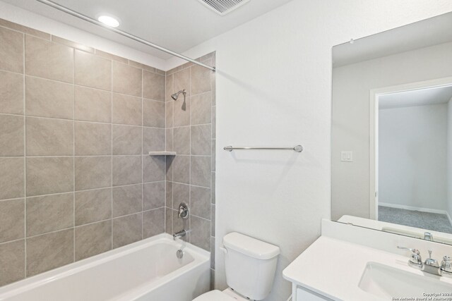 full bathroom with vanity, tiled shower / bath combo, and toilet