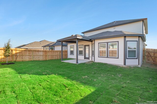 back of house featuring a patio and a lawn