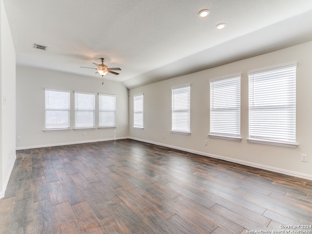 empty room with dark wood-type flooring, ceiling fan, and lofted ceiling