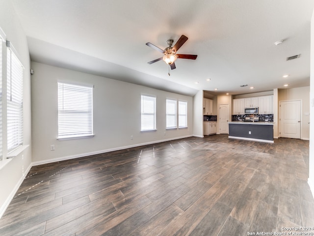 unfurnished living room featuring ceiling fan and dark hardwood / wood-style flooring