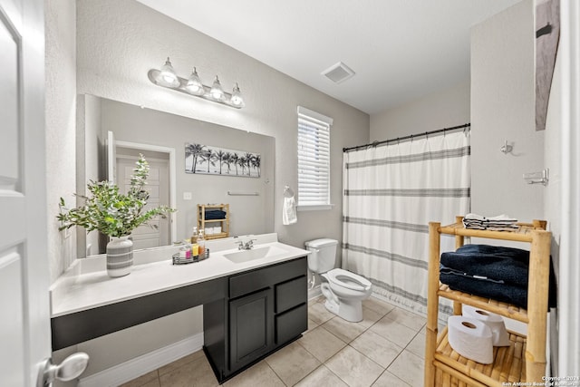 bathroom with vanity, toilet, tile patterned floors, and walk in shower