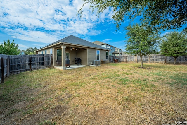 rear view of property with a patio, a yard, central air condition unit, and ceiling fan