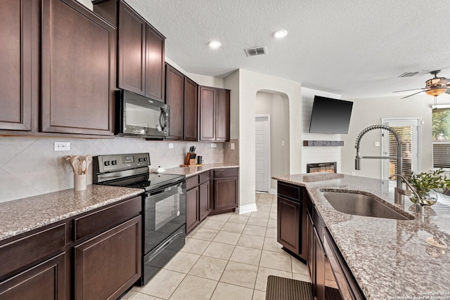 kitchen featuring dark brown cabinetry, a textured ceiling, black appliances, and sink