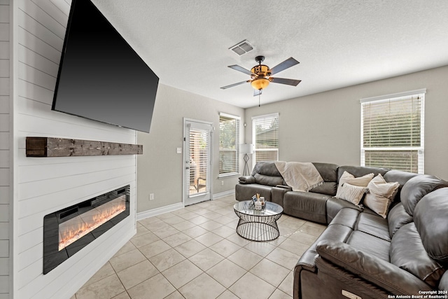 tiled living room with ceiling fan and a textured ceiling