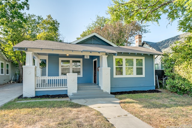 bungalow-style house with covered porch and a front lawn