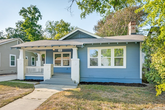 bungalow with a front yard and a porch