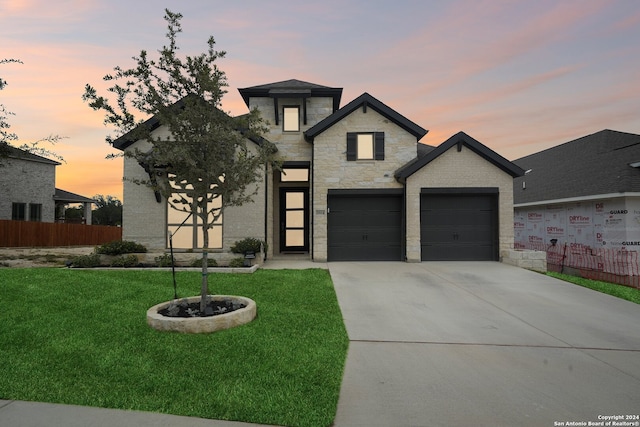 view of front of property featuring a yard and a garage