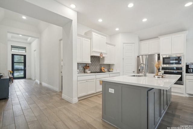 kitchen featuring sink, appliances with stainless steel finishes, light wood-type flooring, and white cabinets